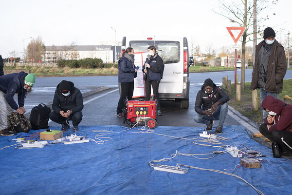 Deux fois par semaine, les bénévoles et les salariés du Secours Catholique de Calais installent un groupe électrogène à proximité des lieux de vie des personnes migrantes pour leur permettre de recharger leur téléphone portable. 