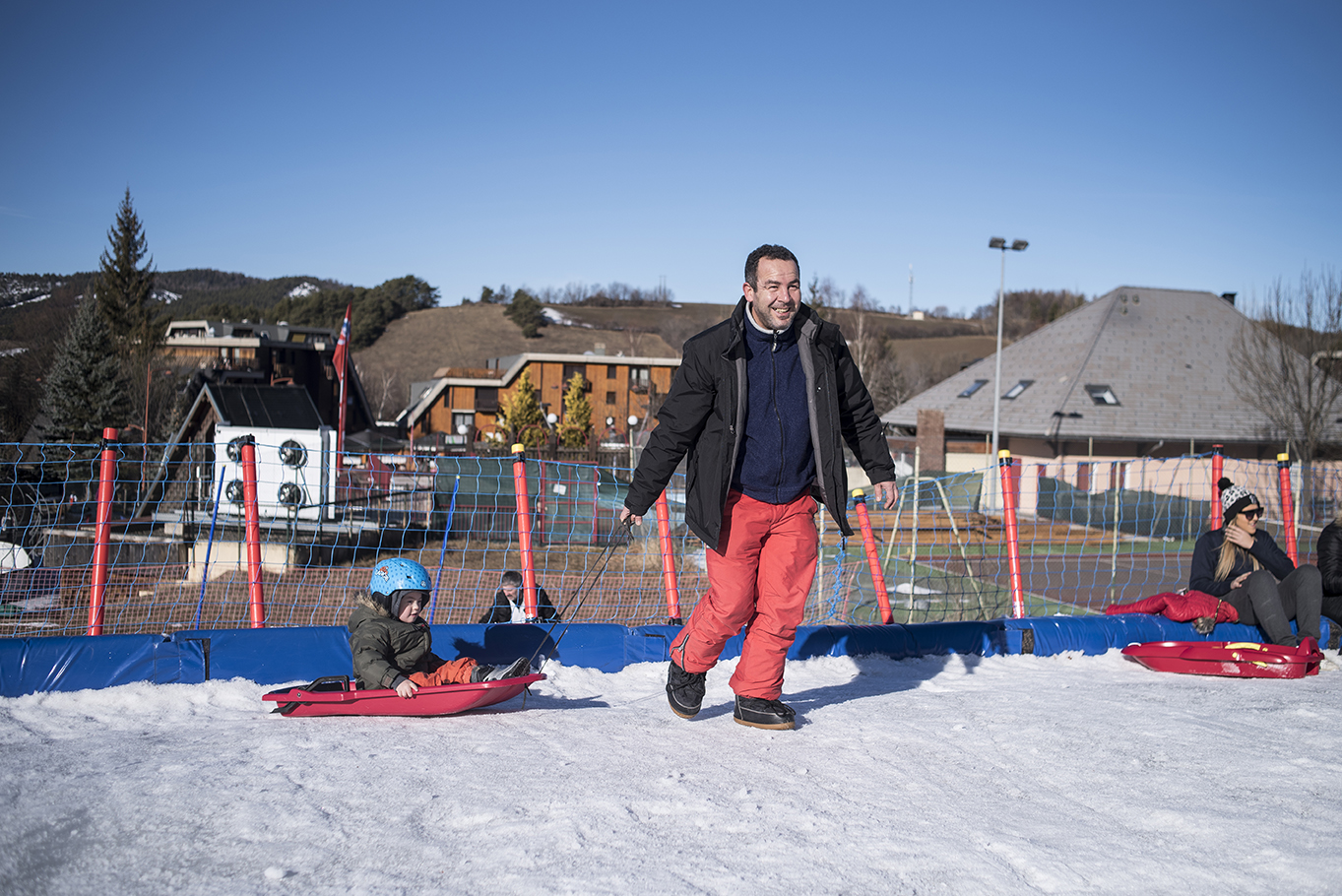 Un père tire la luge de son enfant