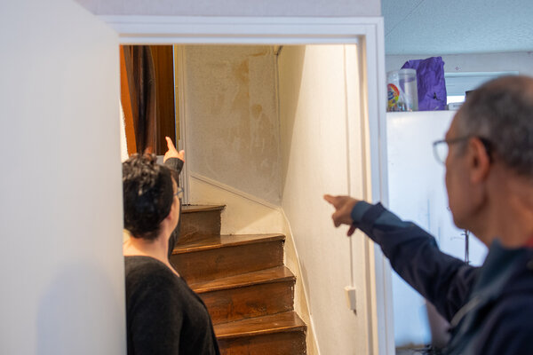 Le bénévole montre du doigt des dégradations dans la maison