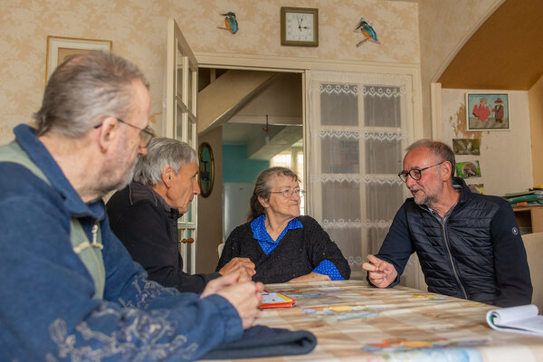 Les bénévoles et le couple autour de la table du séjour