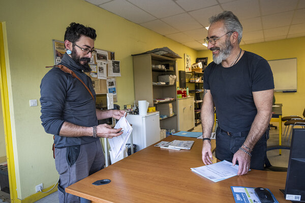 François (responsable technique salarié du garage) finalise la vente d'une voiture à Mathieu.