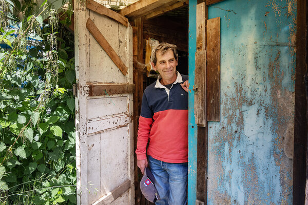 Christophe, devant un abri de jardin