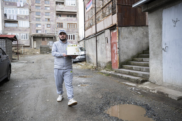 Tigran portant un gâteau confectionné par sa mère chez un client