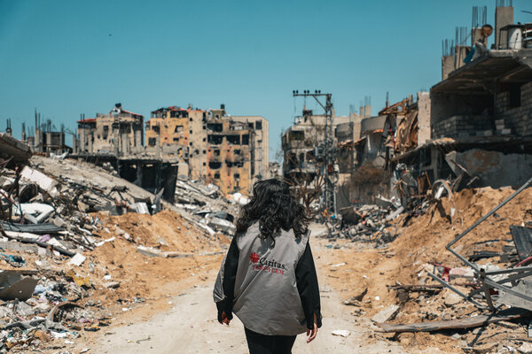 un membre de Caritas  dans une rue bombardée