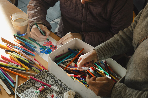 gros plan sur des feutres et un homme en train de dessiner