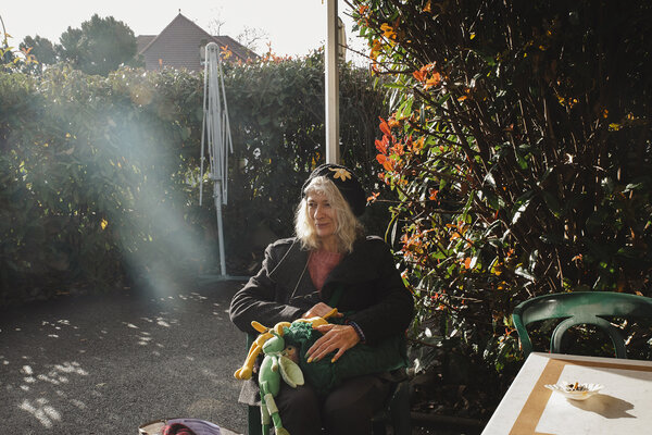 Isabelle assise sur une chaise, dans le jardin