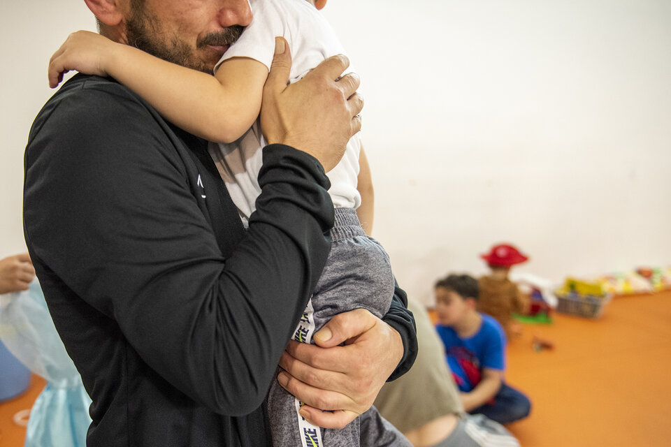 Un père serrant son enfants dans ses bras