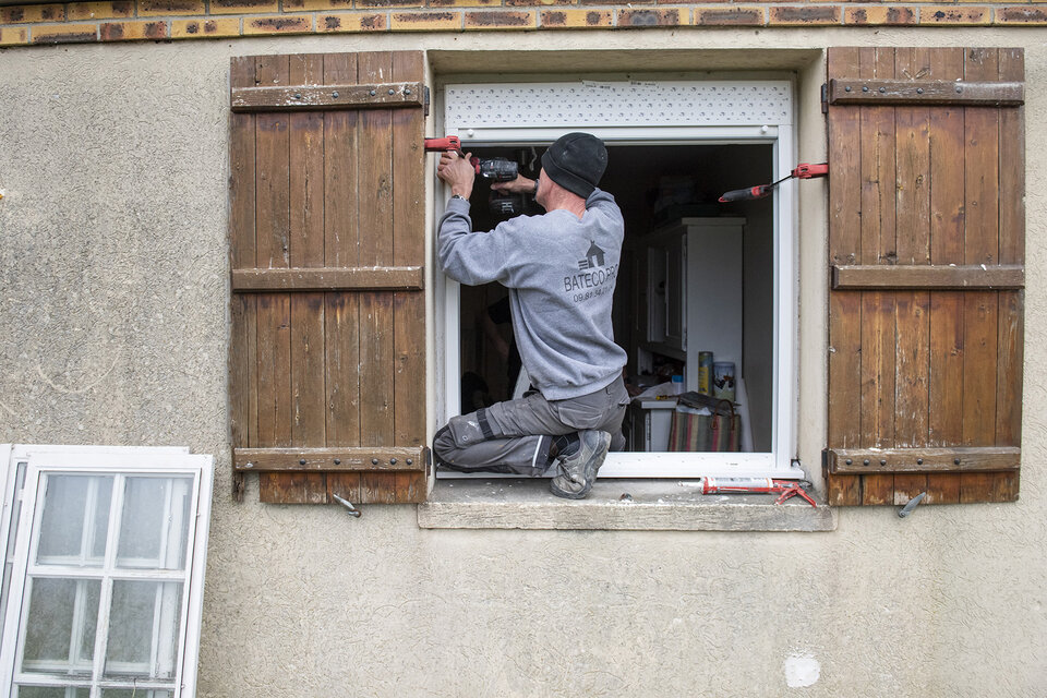 Homme réparant une fenêtre